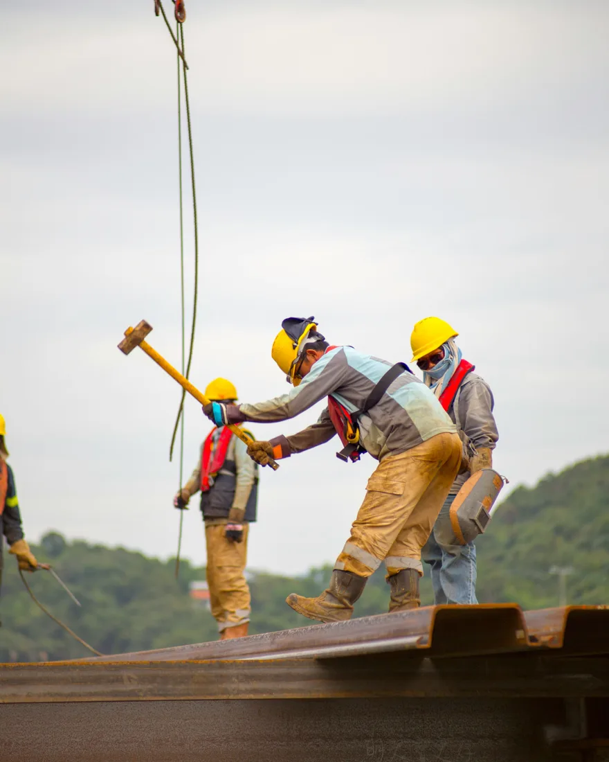Operários de capacete trabalhando em obra